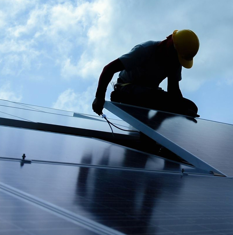 Montør sætter solcelleanlæg til erhverv på bygning